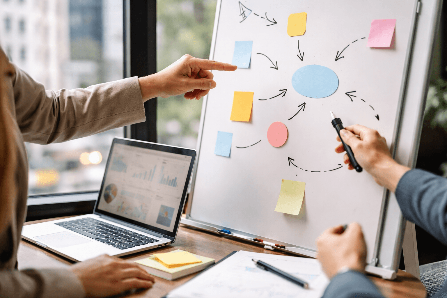 Co-working space during a client call with a designer pointing to a whiteboard plan